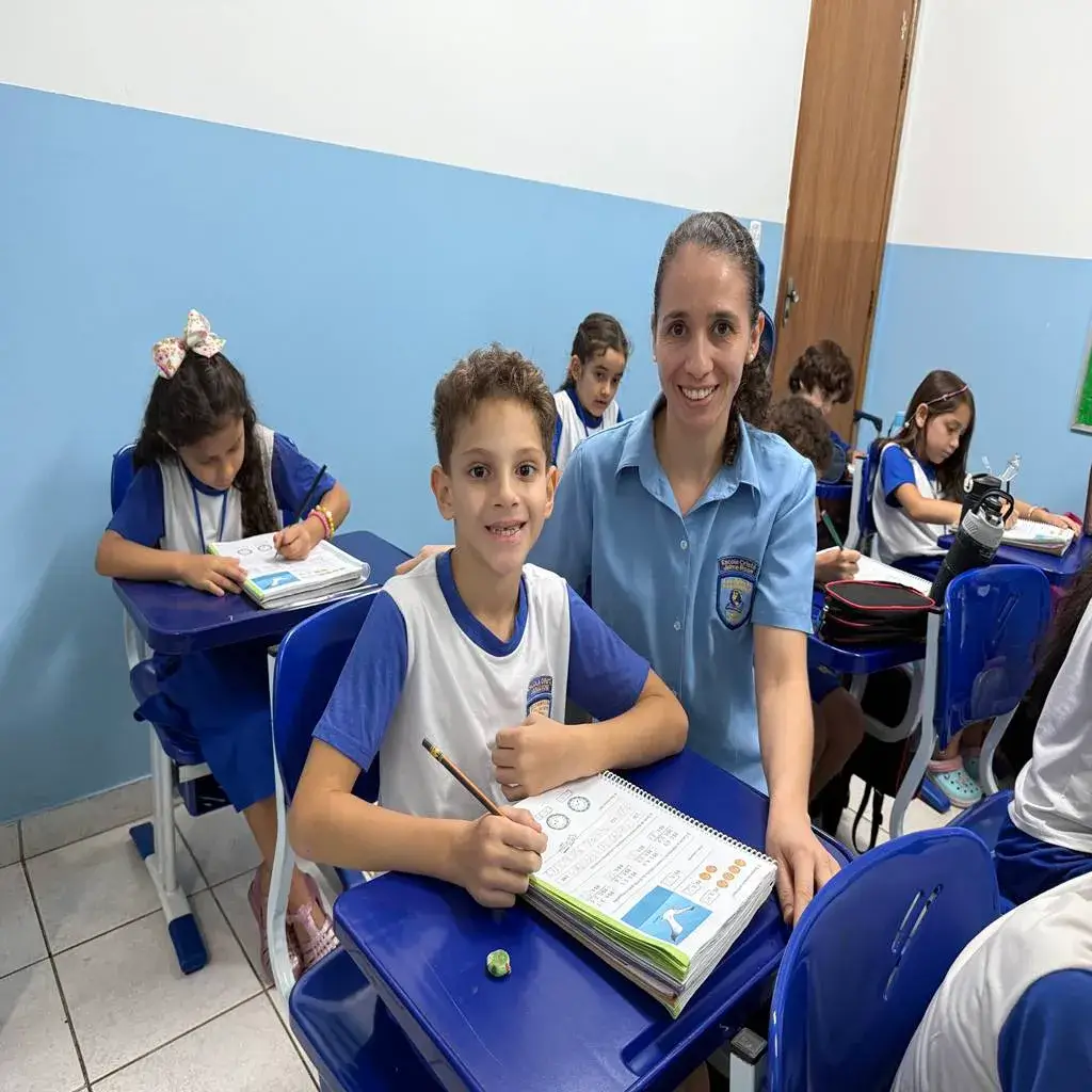 professora dando atenção individualizada a um aluno da escola jaime rose